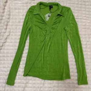 Grön långärmad topp med krage - Snygg grön långärmad topp med krage och rynkdetaljer framtill från zara. Helt ny inte alls använd