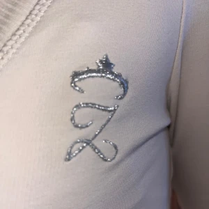 Vit långärmad tröja med broderad detalj - Säljer en super fin tröja med ett glittrigt z med en krona 🩷 den fint skick förutom att den har en liten fläck på ärmen som knappt syns🩷 (pris diskuterbart) 