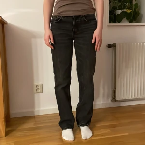 Gråa jeans från Zara - Snygga svarta jeans från Zara med  raka ben. Klassisk design med fem fickor och knappgylf. 