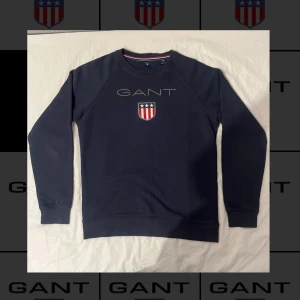 Marinblå Långärmad tröja från GANT  - Marinblå GANT-tröja i 90% bomull och 10% polyester. Töjan har anvönts men väldigt lite vilket synns på dess skick då den inte är sliten eller har några skador alls.   Storleken på tröjan är 176cm/16 år men passar även bra som en S. Normal i storleken. Mått följer nedan.   Axelbredd: 45cm Längd: 65cm Ärmlängd: 56cm Behöver du fler mått? Tveka inte att höra av dig!  Skickas inom 24h efter beställning. SENAST 48h efter beställning. Vid fler frågor eller funderingar, tveka inte att höra av dig!