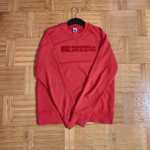 Tröja, Storlek M - Säljer en röd sweatshirt från Russell Athletic som har en broderad logga på bröstet, Bra skick inga skador/slitage, Storlek M, PRIS KAN DISKUTERAS 