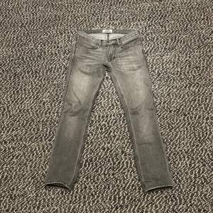Snygga grå jeans från Acne Studios i modellen 'Vintage Grey'. De har en klassisk femficksdesign och är tillverkade i 100% bomull. Perfekta för en stilren look. Det står stprlek 28 men de passar lite större. Har själv storlek 30 i vanliga fall men haft det trots att de sitter smått.