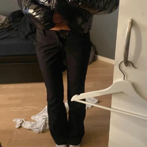 Kostymbyxor från Bik Bok - Snygga svarta kostymbyxor från Bik Bok i storlek 34. Byxorna har en bootcut-stil och är lågmidjade med dragkedja och knapp framtill. Perfekta för en stilren look. Lige korta på mig som är 163