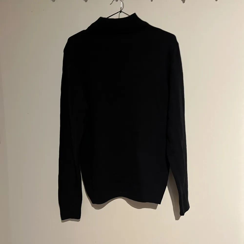 Säljer en stilren svart polotröja från DeFacto. Tröjan har en klassisk design med långa ärmar och en hög krage, perfekt för kyligare dagar. Den är tillverkad i ett mjukt material som ger en bekväm passform. Passar utmärkt till både vardag och mer uppklädda tillfällen.. Neuletakit & Villapaidat.