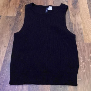 Svart ärmlös topp från H&M Divided - Säljer en svart ribbad topp från H&M i storlek S.  Aldrig använt 