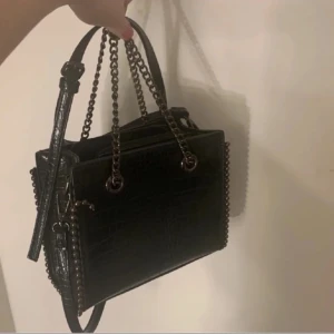 Väska  - Snygg svart axelväska med kedjedetaljer som är andvänd ett fåtal gånger.