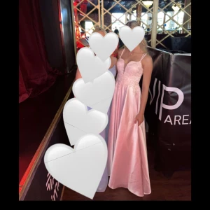 Rosa balklänning  - Säljer min vackra balklänning <3 Elegant rosa långklänning med smala axelband och spetsdetaljer. Klänningen har en vacker slits framtill och en öppen rygg med korsade band. Använd en gång. Nypris 2 271kr