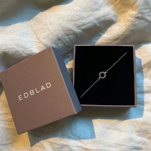 Armband Edblad. - Jättefint silverarmband från Edblad med en liten ring med stenar i. Nypris: 299 kr. Inga defekter förutom en av stenarna som saknas vilket typ inte syns💗