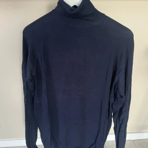 Mörkblå polotröja från Zara - Säljer en stilren och bekväm mörkblå polotröja från Zara. Perfekt för kyligare dagar med sin långa ärmar och mjuka material. Passar både till vardags och lite finare tillfällen. 🧥✨