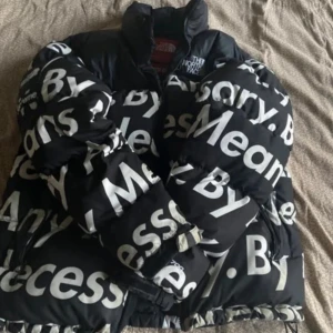Supreme x The North Face ”By Any Means” Nuptse Jacket - Worn with care, seldom. Only one previous owner. Goose Down. Really breathe-able. Size: Medium, feels like large Defects: Slight wear & tear on cuffs Waist-band showing on inside of jacket 1 scratch on one of the s's in the front of the jacket.