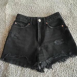 Jeansshorts  - Svarta jeansshorts med slitningar. 