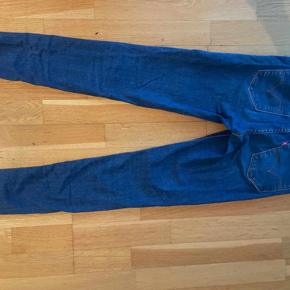 Säljer ett par snygga blå jeans från Levi's. De är högmidjade och super skinny, vilket ger en tight och smickrande passform. Perfekta för både vardag och fest! Bra skick. . Jeans & Byxor.