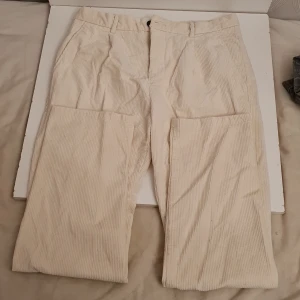 Beige manchesterbyxor från H&M - Säljer ett par snygga beige manchesterbyxor från H&M i storlek EUR 31. Byxorna har en regular fit och är perfekta för höst och vinter. De har en dragkedja och knappar framtill samt två fickor bak med knappar. Superbekväma och stilrena!