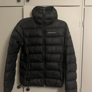 peak performance jacka  - peak performance dunjacka med luva och innerficka, i storlek S, väldigt fint skick, inga skavanker, till synes oanvänd 
