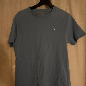 Blå t-shirt från Ralph Lauren - Säljer en snygg blå t-shirt från Ralph Lauren. Den är i väldigt bra skick och i storlek S/176