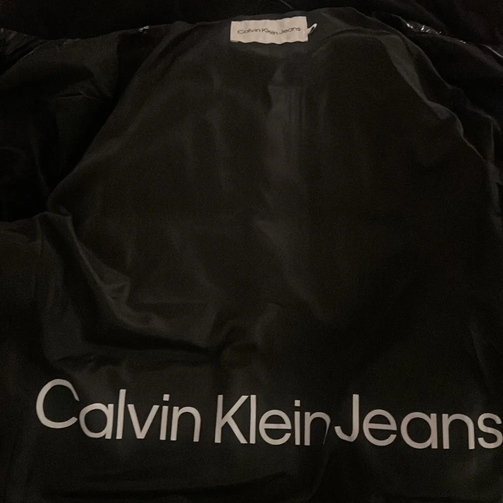 Säljer en snygg svart pufferjacka från Calvin Klein. Köpte för 2195kr Den är i mycket bra skick och perfekt för höst och vinter. Jackan har en glansig finish och dragkedja framtill. Den är långärmad och har en normal passform. Supermysig och stilren för kyliga dagar!❤️❤️💕. Jackor.