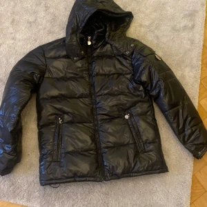 Svart pufferjacka med huva - Säljer denna snygga vinter jacka som jag nyss fått hem den är aldrig använd och ny pris när jag köpte den är 1299kr därav priset. Jag säljer den då den inte passade och jag har inte möjlighet att skicka tillbaka den längre.❤️‍🔥 Priset går att diskuteras❤️
