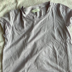 Ljuslila t-shirt från Lindex - Säljer en ljuslila t-shirt från Lindex i storlek XS/146-152. Den är i bomull och har en klassisk rund halsringning. Perfekt för vardagsbruk och kan enkelt matchas med jeans eller kjol. T-shirten är i bra skick. Passar perfekt till vår och sommar!
