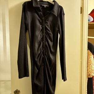 Svart långärmad klänning - Svart långärmad klänning med knappar längs hela. Ribbad och till mitten av låren på mig som är 158 cm. Köpare står för frakt ❤️