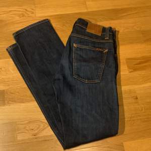 Säljer ett par snygga mörkblå jeans från Nudie Jeans i mycket bra skick.  Bara använda några gånger. Storlek 32/34. Skick 9/10. Hör av er vid frågor!