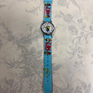 Minions Barn klockor  - Två supercoola klockor med Minion-tema! Den ena har ett ljusblått armband och den andra ett gult. Perfekta för barn som älskar Minions. Klockorna har tydliga siffror och en rolig design med Minion-figurer på armbandet. De är i bra skick och redo att användas för att lära sig klockan eller bara som en rolig accessoar.  Nya batteri, 115kr/st 