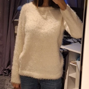 Mysig vit fluffig tröja - Säljer en supermysig vit fluffig tröja som är perfekt för kyliga dagar. Den har en normal passform och långa ärmar, vilket gör den idealisk för både höst och vinter. Tröjan är i bra skick och passar perfekt till jeans för en avslappnad look. 🧥❄️ Är i storlek 150.