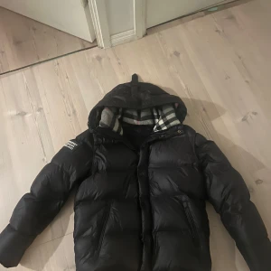 Burberry jacka/väst - Säljer en svart burberry jacka i mycket bra skick. Den är storlek L men passar som M. Använd jätte lite ena fickans dragkedja funkar inte men annars är den bra skick. 