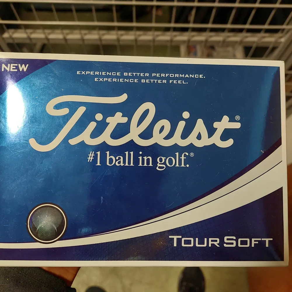 Säljer en förpackning med Titleist Tour Soft golfbollar. Dessa bollar är kända för sin mjuka känsla och utmärkta prestanda på banan. Perfekt för golfare som vill ha en kombination av längd och kontroll. Förpackningen är blå och vit med tydlig Titleist-logga.. Övrigt.