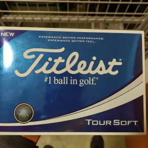 Säljer en förpackning med Titleist Tour Soft golfbollar. Dessa bollar är kända för sin mjuka känsla och utmärkta prestanda på banan. Perfekt för golfare som vill ha en kombination av längd och kontroll. Förpackningen är blå och vit med tydlig Titleist-logga.