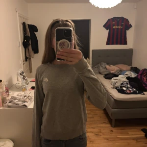 Grå sweatshirt från Nike - Säljer en grå sweatshirt från Nike i bra skick. Den är superbekväm och perfekt för vardagsbruk. Tröjan har långa ärmar och en klassisk rund halsringning. Nike-loggan är broderad på bröstet. Perfekt för höst och vår!
