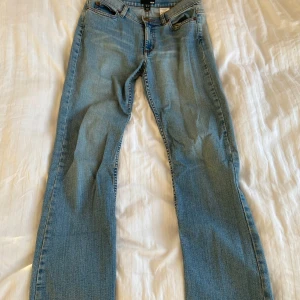 Blå jeans från H&M - Säljer ett par klassiska blå jeans från H&M i storlek 36. De har en straight passform och är i bra skick. Jeansen har snygga detaljer på bakfickorna och är perfekta för vardagsbruk. Passar till alla säsonger och kan enkelt matchas med olika toppar.
