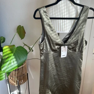 Grön kort satinklänning BikBok - Helt ny satinklänning från BikBok. Helt oanvänd med prislappen kvar 💗 Otroligt gullig kort klänning som går både att klä upp och klä ner.   Nypris: 399kr Mitt pris: 95kr