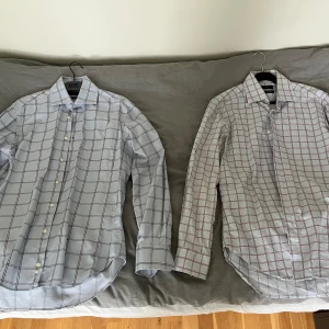 Två rutiga skjortor från Zara - Säljer två snygga rutiga skjortor från Zara i nyskick! Båda är långärmade och gjorda av 100% bomull. Den ena är vit med blå rutor och den andra är vit med röda rutor. Perfekta för både vardag och fest! Pris går att diskuteras🙂.