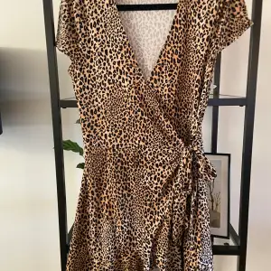 Säljer en superfin leopardmönstrad omlottklänning från H&M:s Divided-kollektion. Klänningen är kortärmad och har en knytning i midjan som ger en snygg passform. Perfekt för en fest eller en utekväll! 🐆