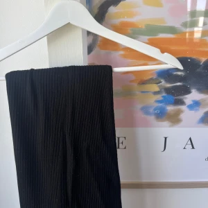 Svart långkjol - Säljer en svart långkjol som är superchic och passar perfekt till både vardag och fest. Kjolen är ribbad och har en tight passform som framhäver figuren på ett snyggt sätt. Den är gjord av ett mjukt och stretchigt material som gör den bekväm att bära hela dagen.