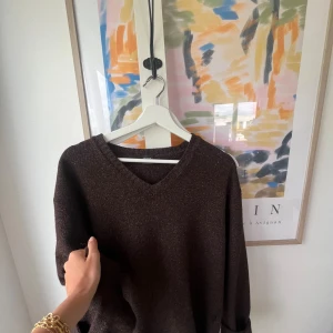 Brun stickad tröja - Säljer en mysig brun stickad tröja med v-ringning. Tröjan har långa ärmar och en normal passform. Perfekt för höst och vinter!