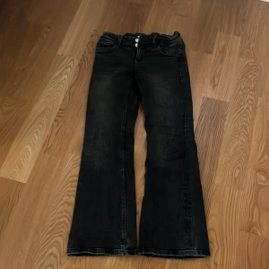 Svarta bootcut jeans från Gina Tricot - Säljer ett par lågmidjade svarta bootcut jeans från Gina Tricot i storlek 152. Jeansen stängs med dragkedja och två knappar. De är i bra skick och perfekta för både vardag och fest. Passar till alla tillfällen och är superbekväma!