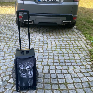  Konståkningsväska -  Konståkning väska med en tiger på jättemånga fickor använd några gånger ögonen på tigern lyser i mörkret och blinkar när man drar en flera innerfickor och fyra ute fickor på vardera sida köpt  från züka kommer med ett blått hopprep