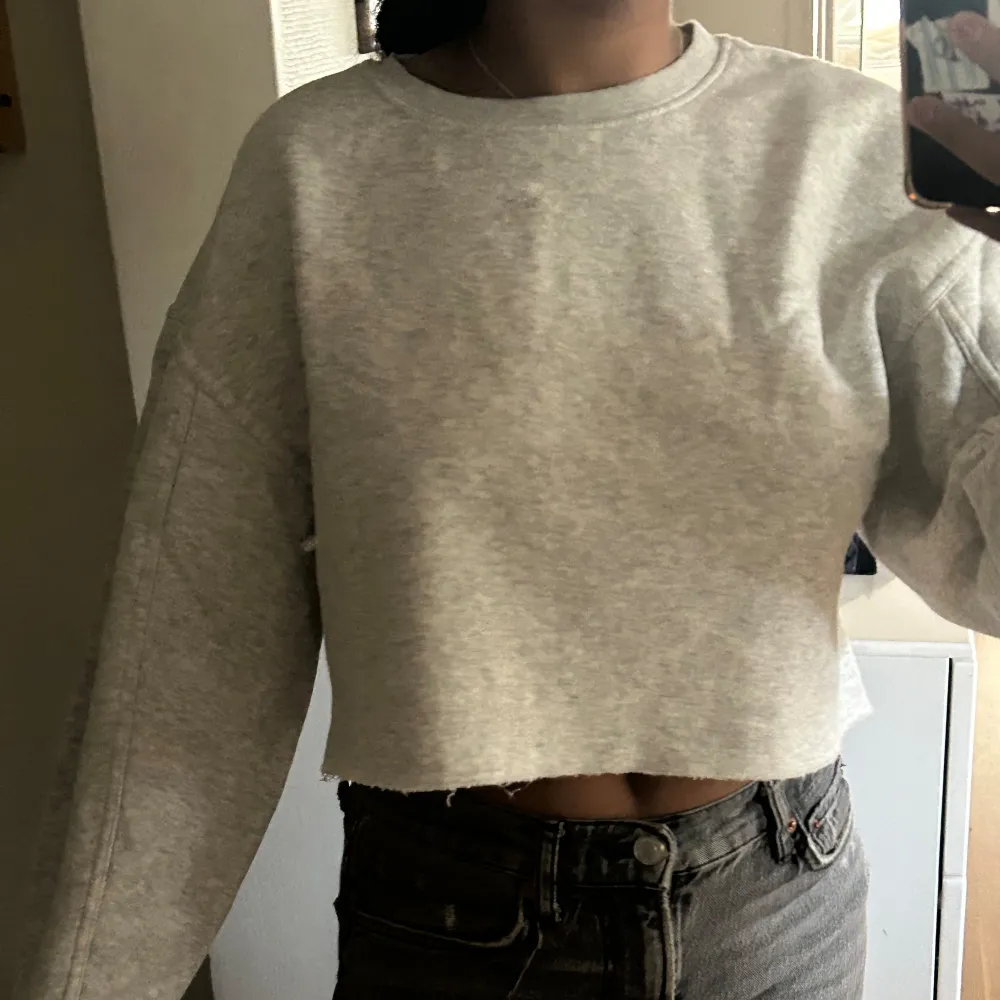 Säljer en superfin grå croppad sweatshirt. Den är perfekt för en avslappnad look och passar till både jeans och leggings eller över klänning/kjol. Tröjan är långärmad och har en normal passform. Materialet är mjukt och bekvämt, perfekt för höst och vår. Super fin eftersom den har lite ballong ärmar. Den är i nyskick och knappt använd. Perfekt för en chill dag eller en casual utflykt. 🩶. Tröjor & Koftor.