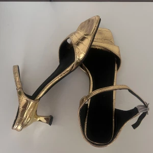 Guld klackar - korta klackar  - Säljer dessa super fina guldiga klackar i ca 4cm klack. Väldigt bekväma, använda 1 gång under balen och hade inga problem. Tecken på användning finns💛