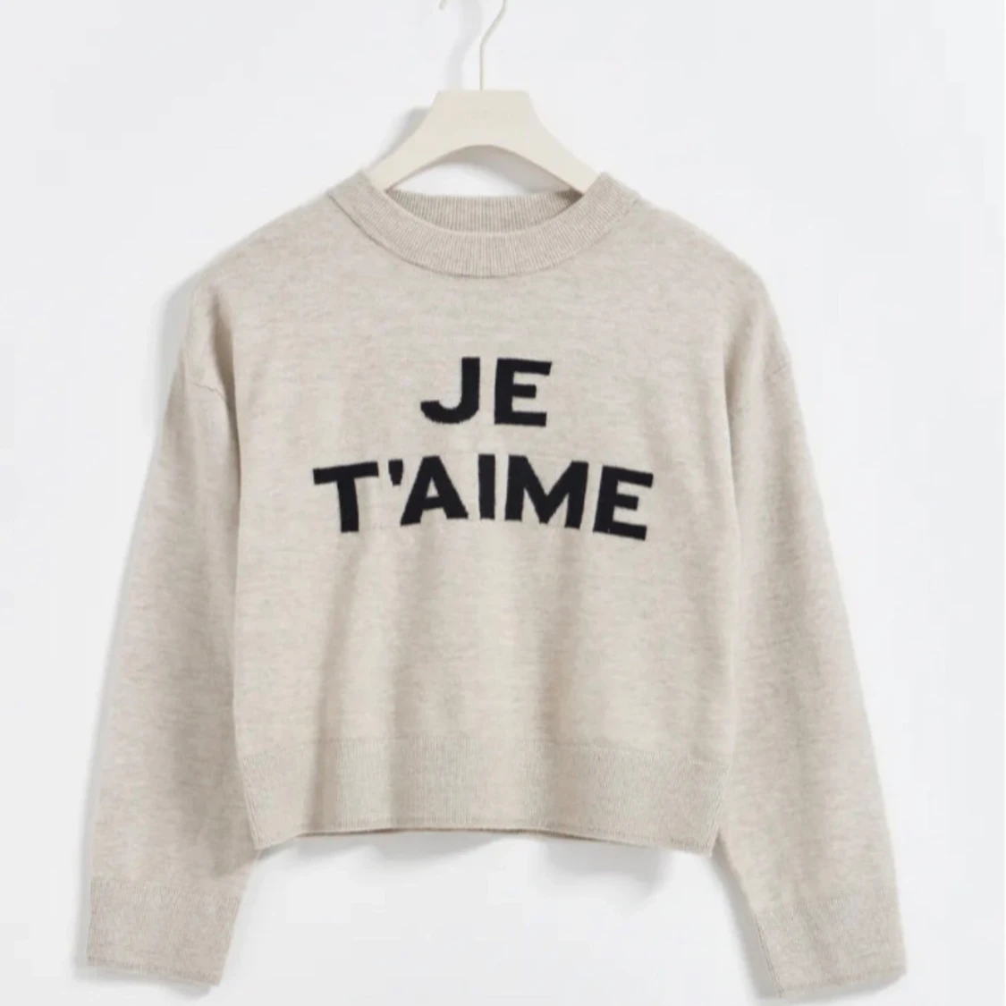 Beige stickad tröja med text