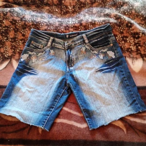 Jeans shorts med applikationer stl 44  - Tuffa jeans shorts med applikationer fram och bak samt fickor både fram och bak .stl 44. Märke Big Spade jeans.