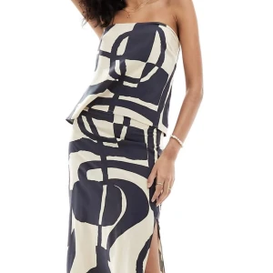 Svartvitt set med kjol och bandeau topp  - Säljer detta super fina set som är ifrån ASOS. Det är en svartvit mönstrad maxikjol med benslits och en bandeau topp i samma mönster med knytning i ryggen. Går även bra att köpa de separat, båda delarna är helt oanvända prislapparna sitter kvar🩷🩷