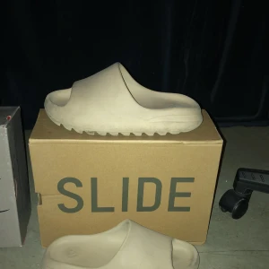 Yeezy slides  - Hej säljer nu mina yeezy slides i storlek 42. Tofflorna är i använt skick och säljer de då jag inte längre använder de. Lådan ingår! Kan mötas i Stockholm.