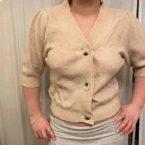 Stickad tröja från neo noir - Beige kofta från neo noir i superbra skick. Perfekt nu till hösten! 