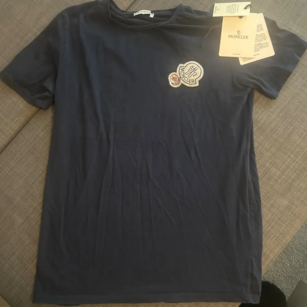 En Moncler T-shirt i bra skick. Står storlek L i men passar som S. Tagsen medföljer inte. Pris kan diskuteras vid snabbaffär.. T-shirts.