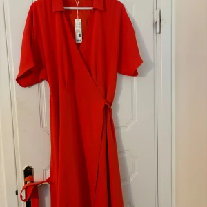 Klänning - Orange klänning som aldrig används. Prislapp sitter kvar.