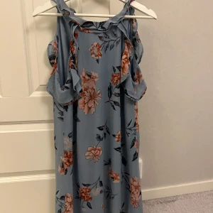 Blommig midiklänning - Säljer en blå, blommig midiklänning i storlek M💕