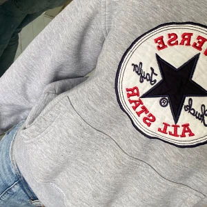 Grå hoodie från Converse - Säljer en snygg och bekväm grå hoodie från Converse med det klassiska All Star-loggan på bröstet. Det står storlek M på lappen på tröjan men skulle mera passa på någon som har s/xs!!! liten fettfläck som syns på tredje bilden men man märker det inte alls💞💞 köpta för ca 300 på sellpy