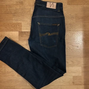 Nudie jeans - Snygga mörkblå jeans från Nudie Jeans i modellen Tape Ted. Säljer eftersom att de inte helt och hållet passade till min preferens. Skick:9/10. Storlek 32L 31W. Perfekta för det nuvarande modet.
